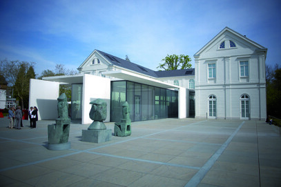 Max Ernst Museum Brühl des LVR (Seitliche Außenansicht des Max Ernst Museums Brühl des LVR mit drei Skulpturen im Vordergrund.)